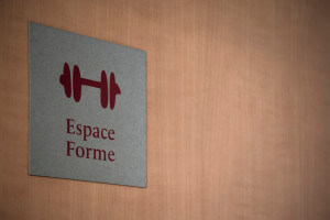 Signalétique sur une porte avec "espace forme" écrit et le dessin d'une haltère