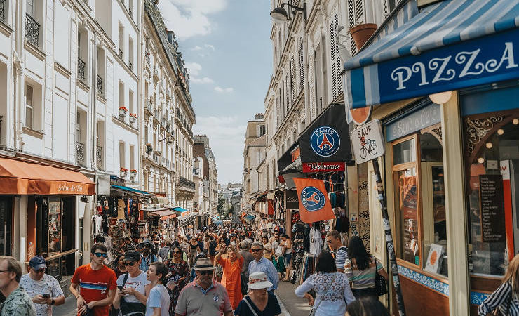 rue de Paris avec piétons sous le soleil