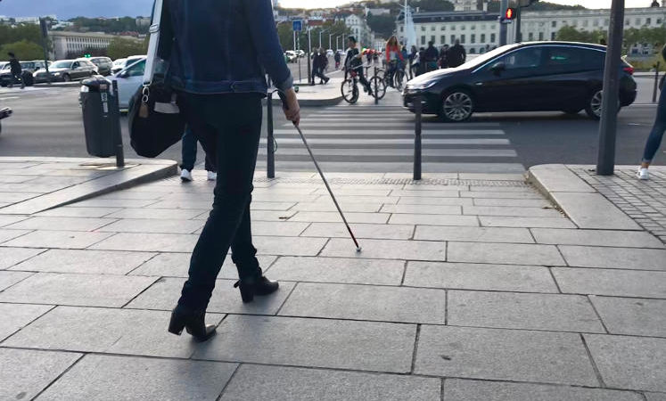 personne aveugle traversant la rue