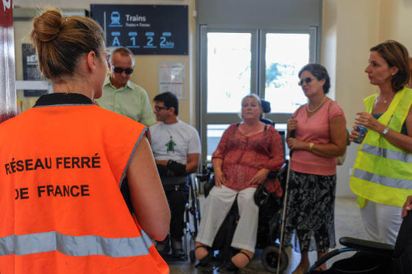 Groupe de personnes en situation de handicap avec une personne de la SNCF pour échnager sur l'accessibiltié