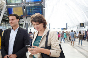Voyageur utilisant une application de guidage sur smartphone dans une gare