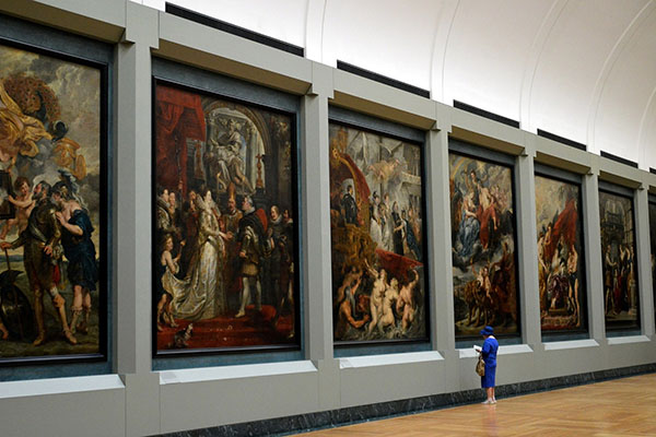 Une femme admire des peintures à un musée