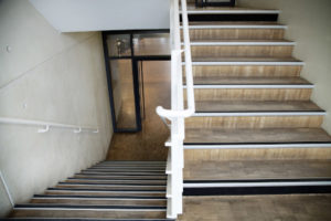 Un escalier sécurisé avec bande podotactile d'éveil de vigilance, nez de marches et contremarches et mains courantes