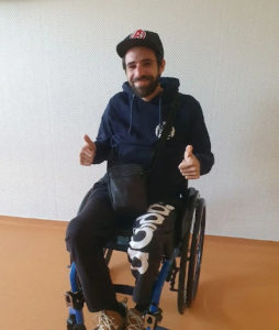 Portrait de Mathias Polin, utilisateur de fauteuil roulant qui fait un grand sourire